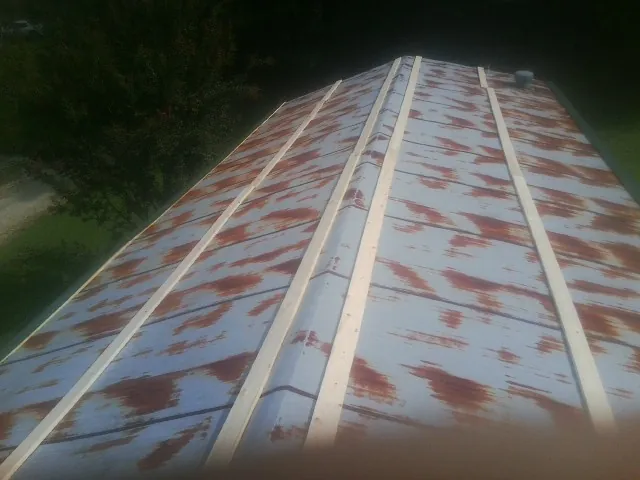 Rusted metal roof panels with new wood purlins before replacement — Storm Damage Roof Repair in Myton by Roofing Brothers