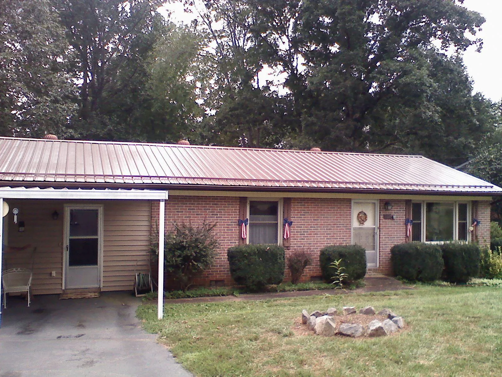 Bronze metal roof and carport on a brick ranch home — Roof Repair work by our crew in Myton